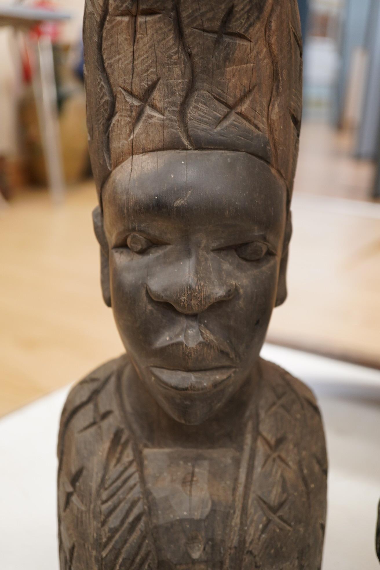 An African hardwood carving of a bust, 41cm high and an ebony Indian carving of a lion, 35cm long, (2). Condition - fair